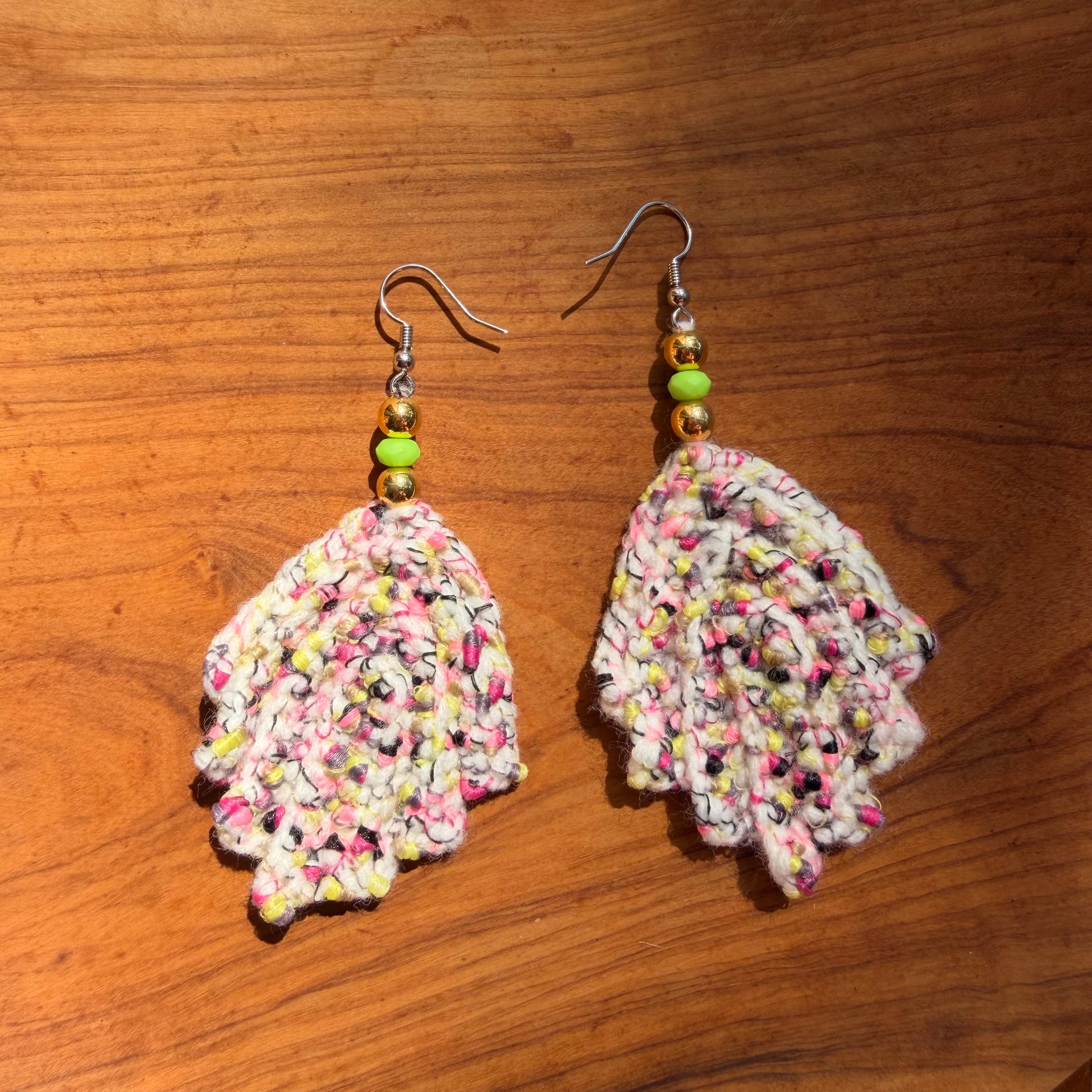 Colorful crocheted earrings on a wooden surface